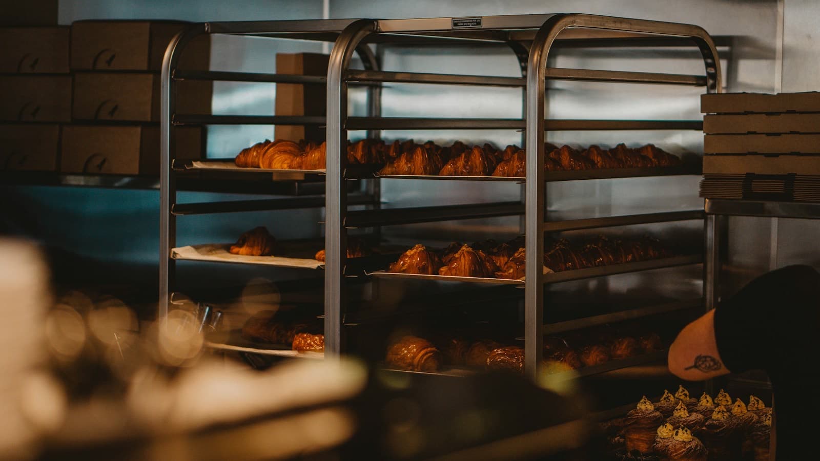Trays of croissants on a steel rack behind the counter of a Melbourne bakery